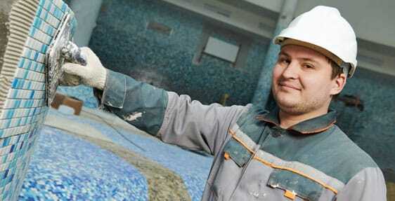Pool Tile Repair This image shows a man installing new pool tiles.