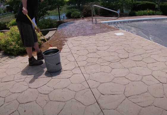 This image shows men resurfacing a pool deck.