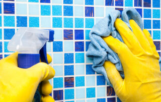 This image shows a hand cleaning a pool tile.